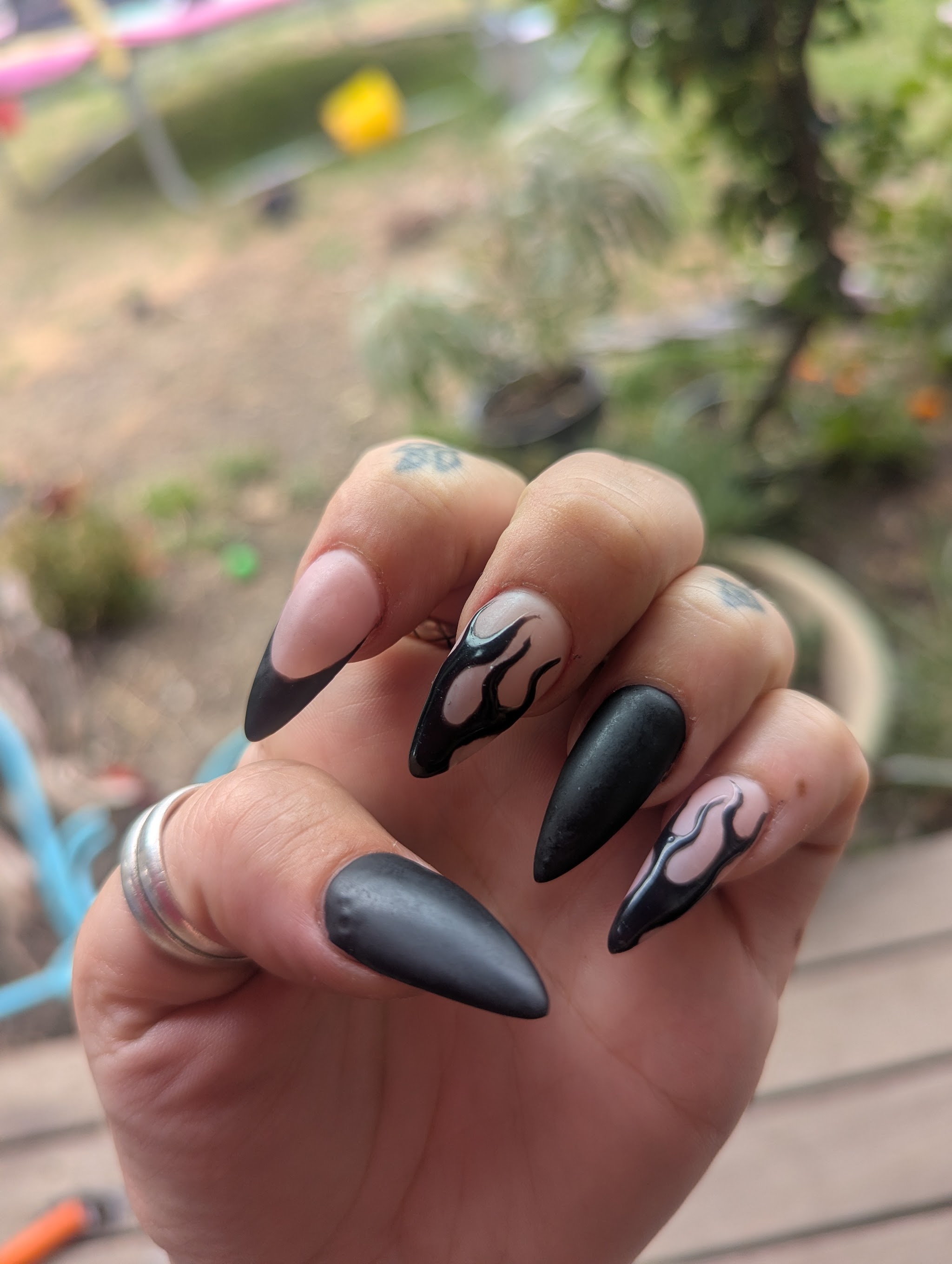 Matte black stiletto nails with hand painted flame detail